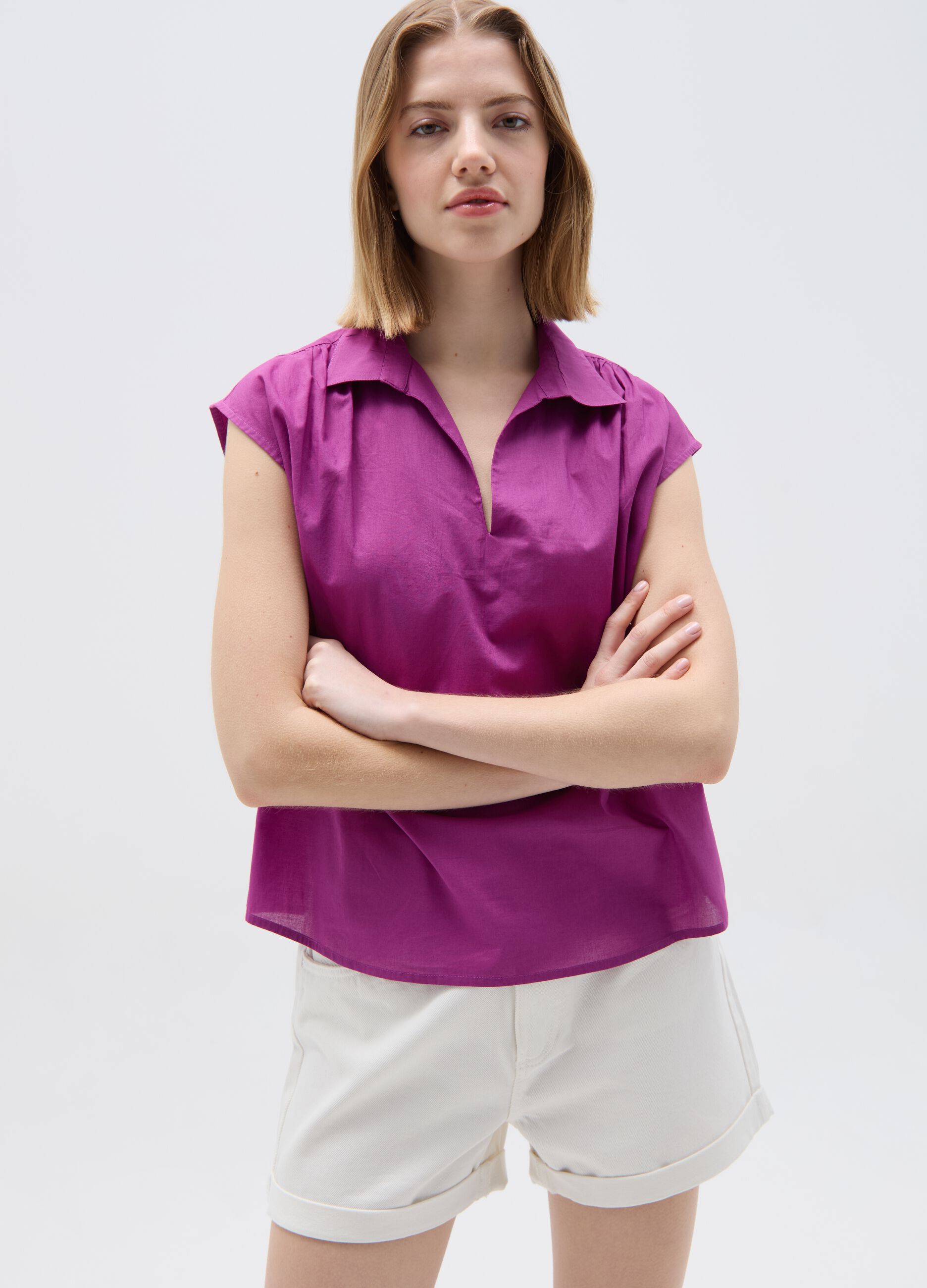 Sleeveless blouse with polo neck