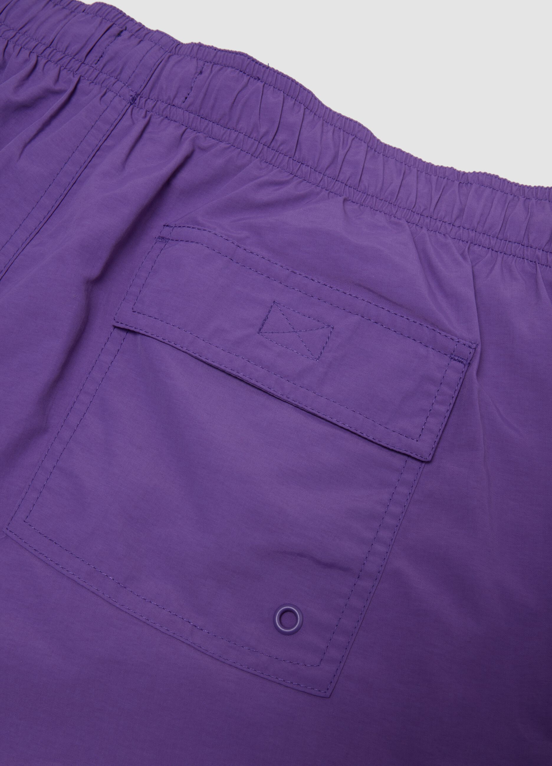 Purple swim shorts with elasticated waistband and drawstring