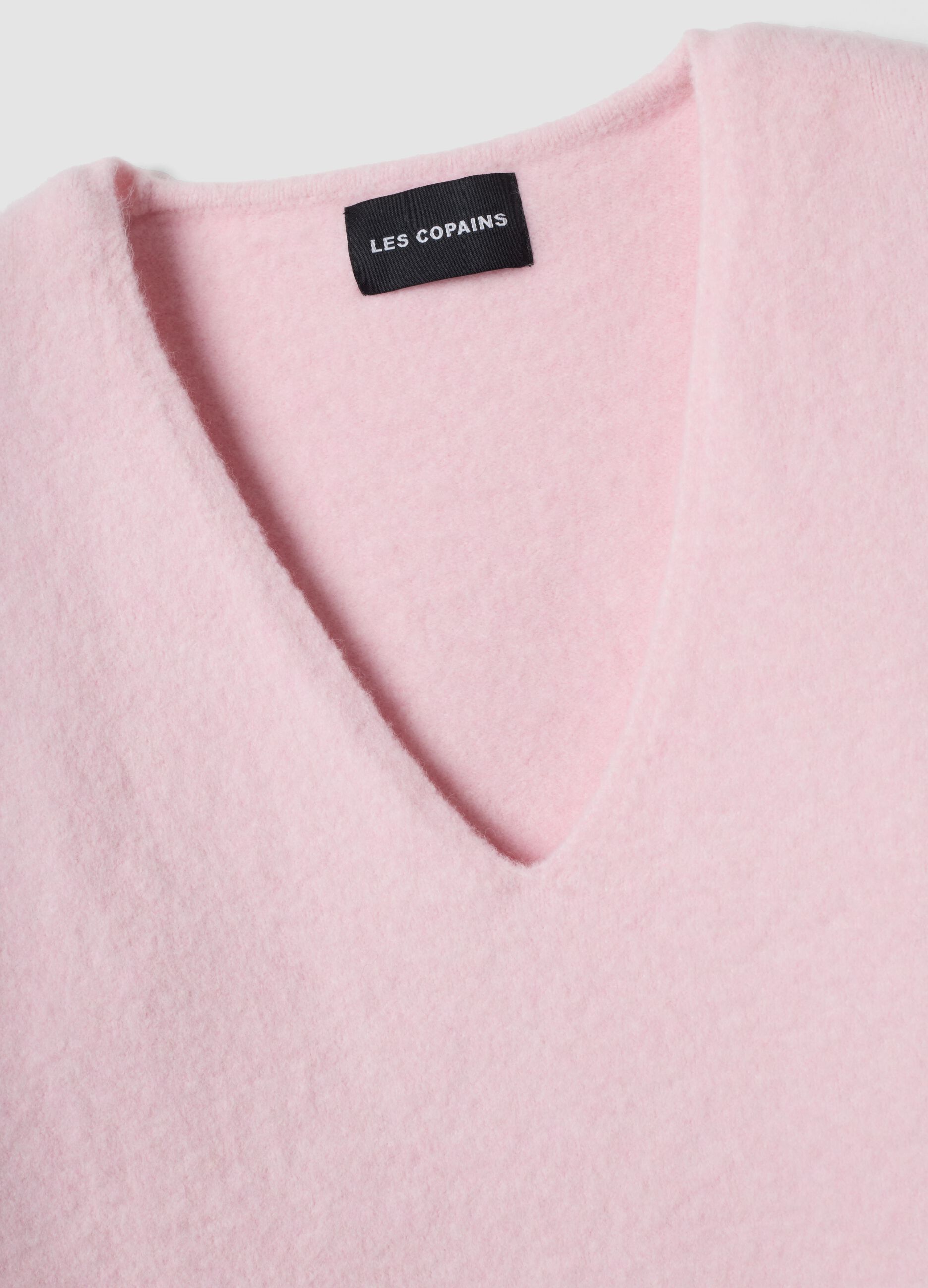 Pink stretch wool jumper with deep V-neck and oversized fit