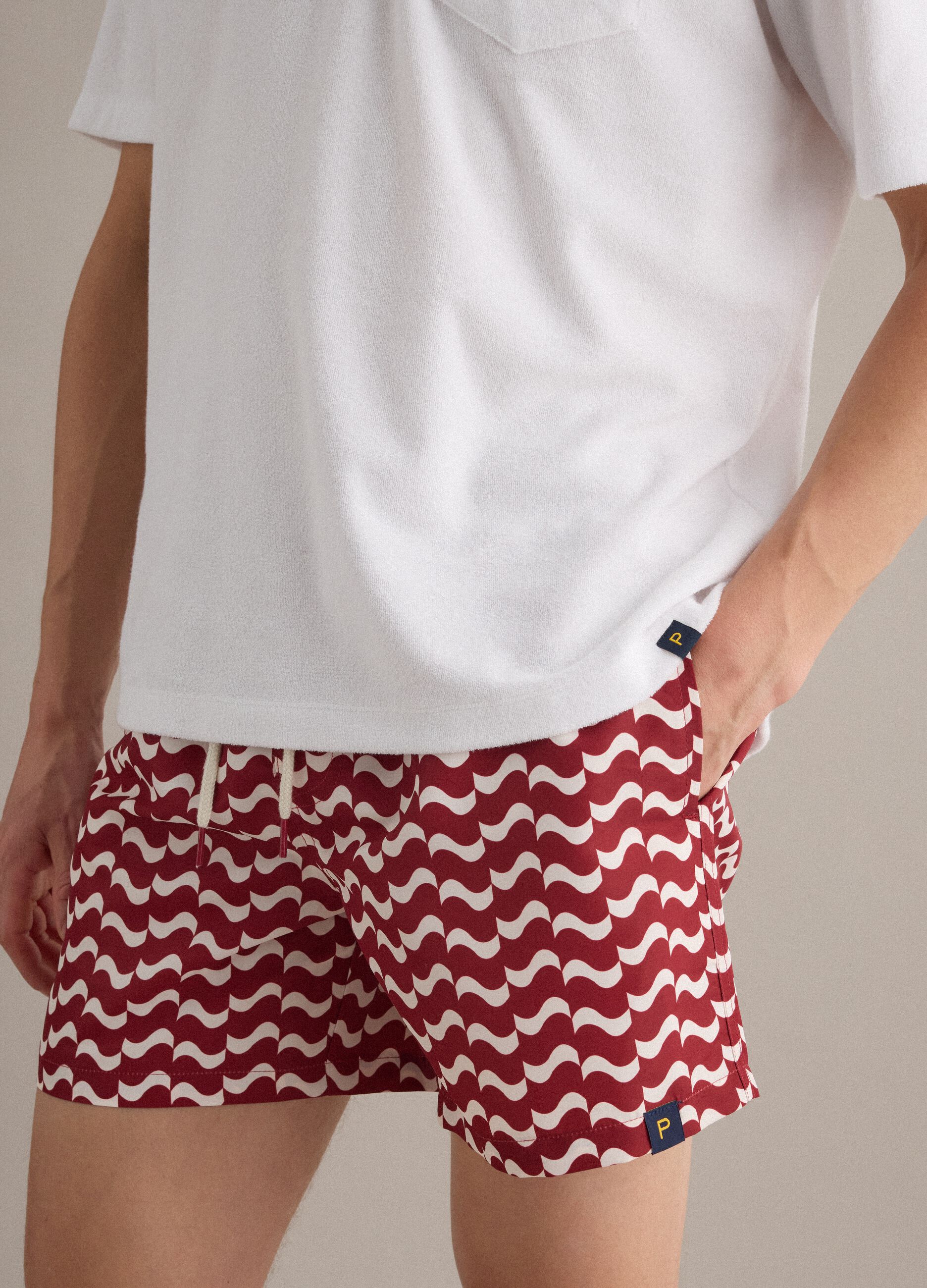 Red men&rsquo;s swim shorts with all-over print