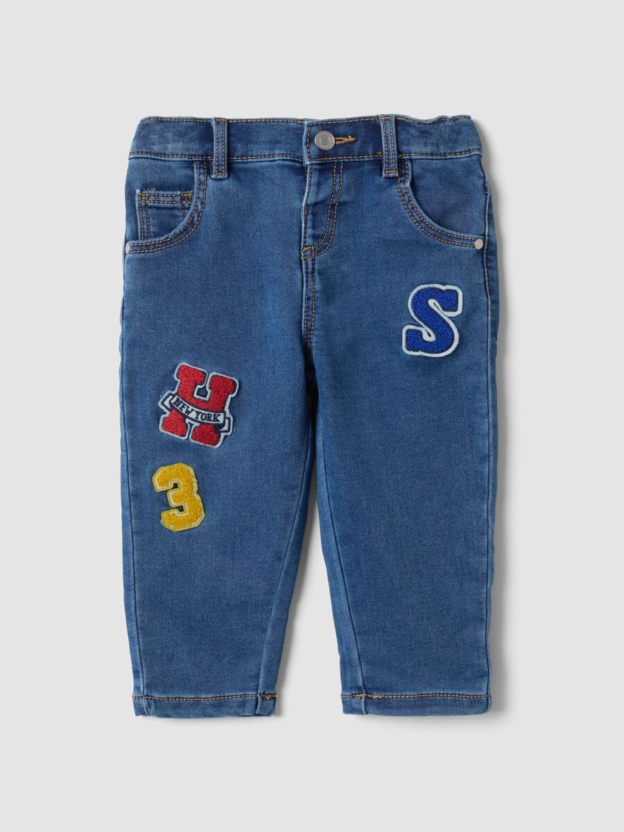 Blue stretch cotton jeans with varsity-style appliqu&eacute;s for baby boy_0