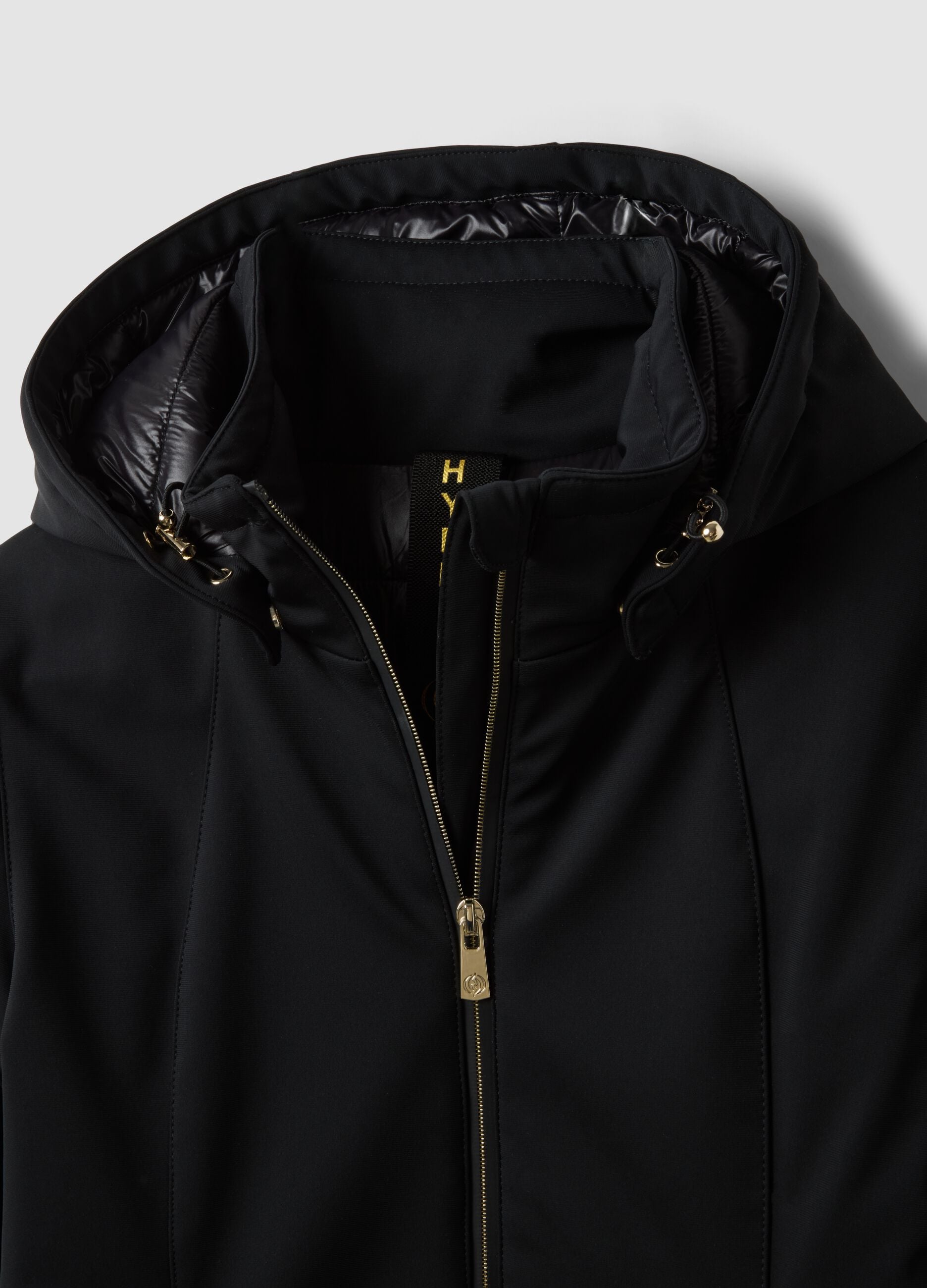 Parka preta em tecido el&aacute;stico com capuz, corte regular