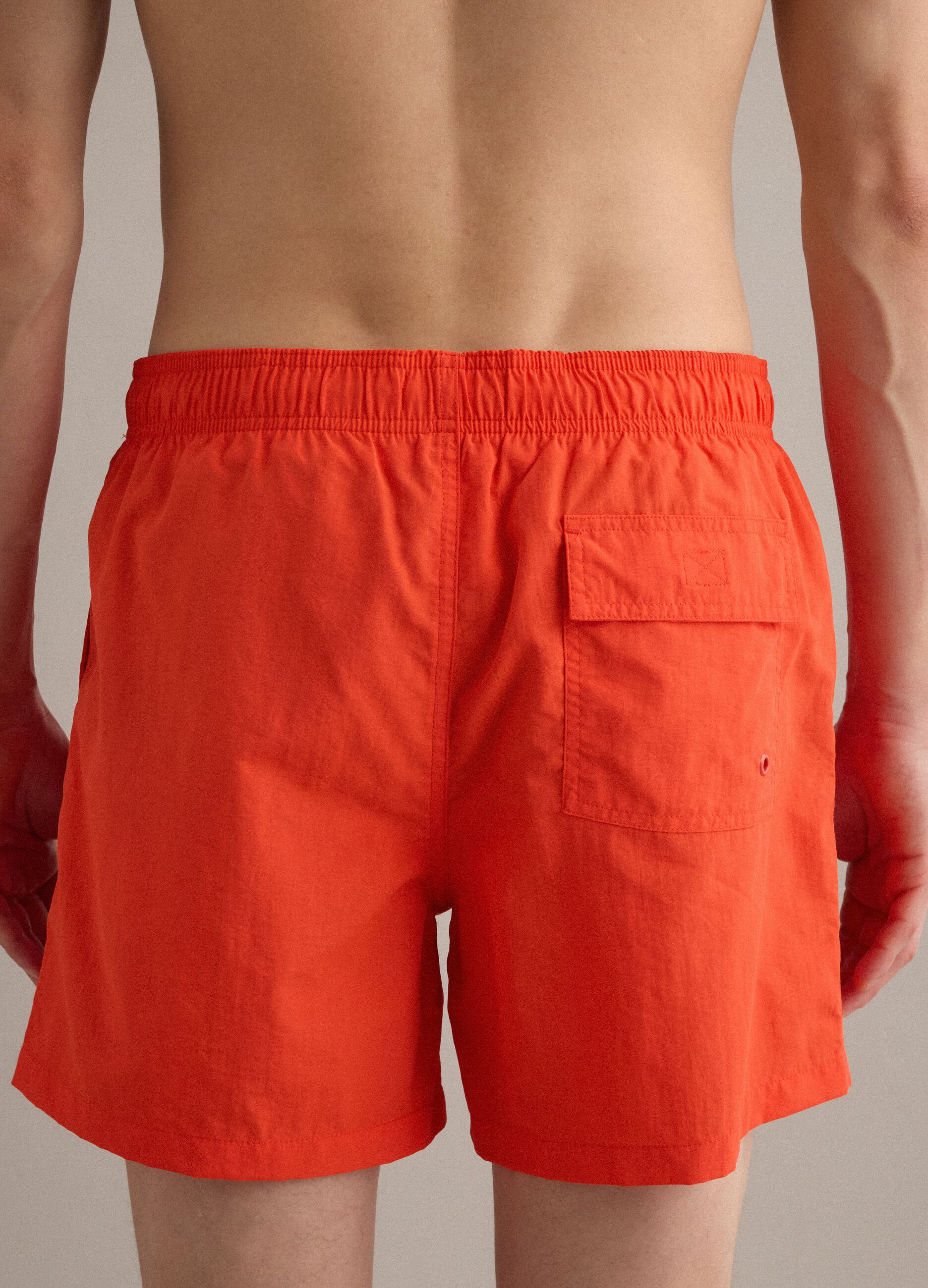 Orangefarbene Badeshorts mit elastischem Bund und Kordelzug