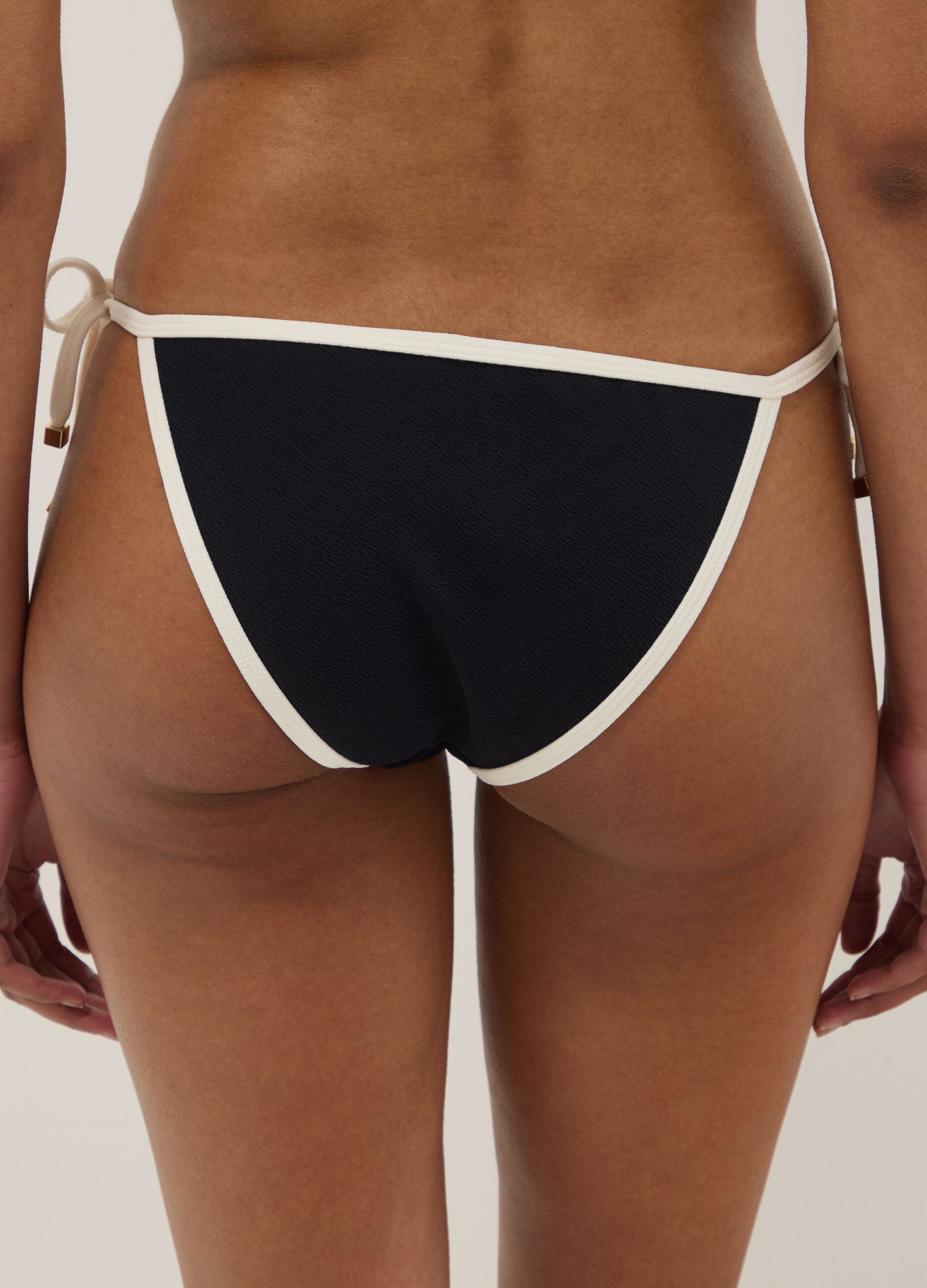 Cueca de biqu&iacute;ni preta e branca em tecido el&aacute;stico com atilhos laterais