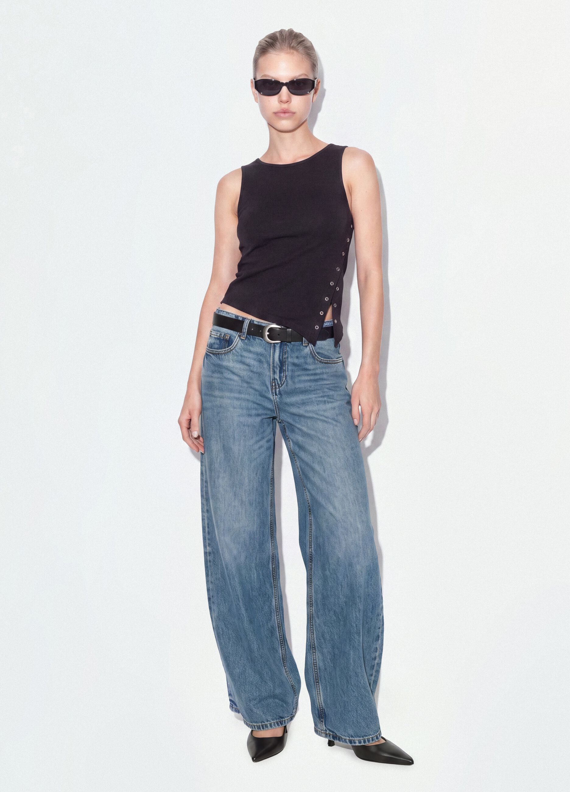Schwarzes Top aus elastischer Baumwolle mit asymmetrischem Saum und Metall&ouml;sen