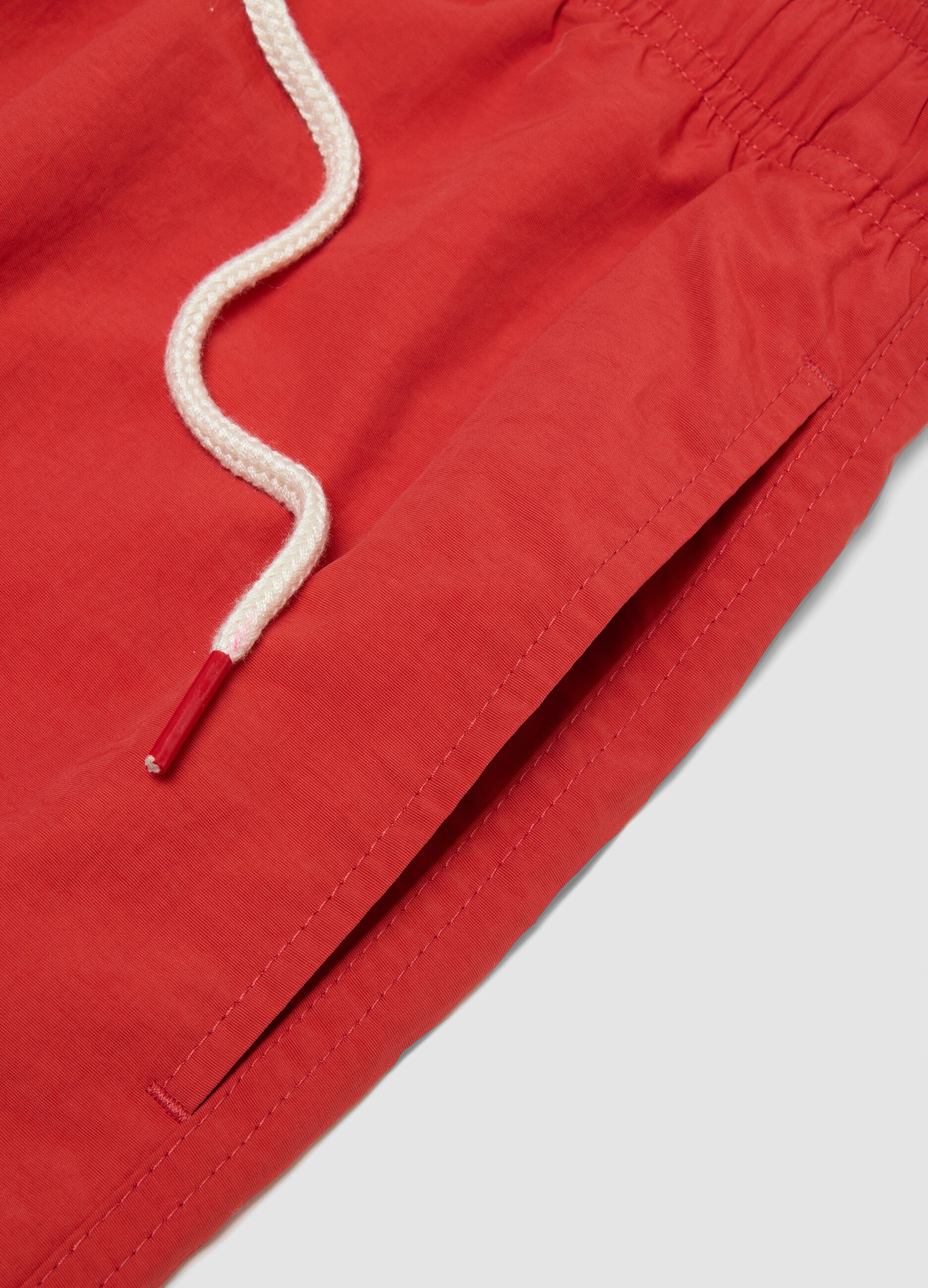 Red swim shorts with elasticated waistband and drawstring