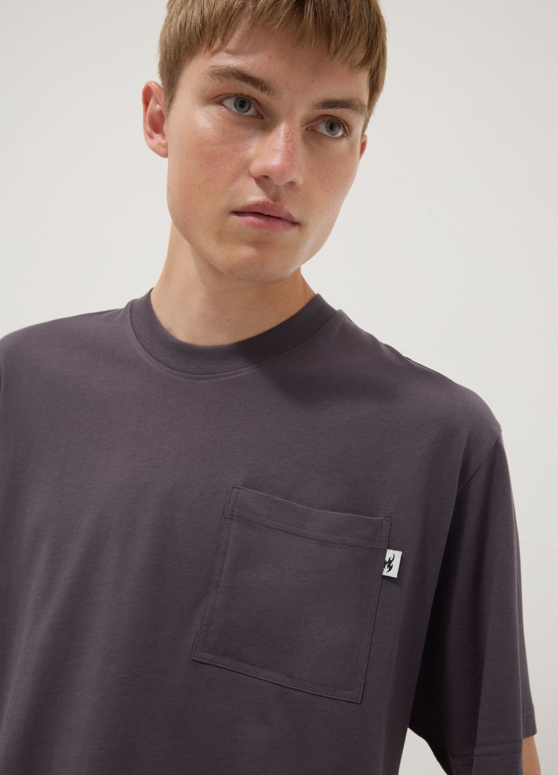 T-shirt cinzenta em algod&atilde;o puro com bolso, corte regular