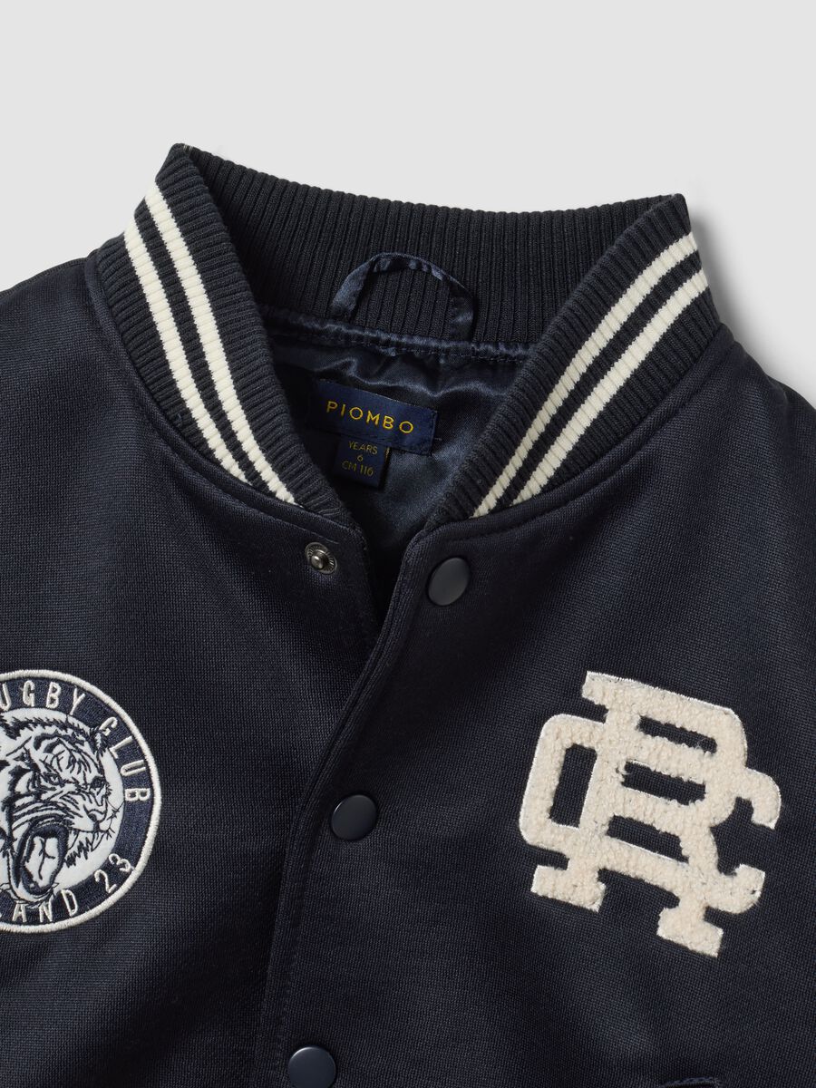 Blue varsity jacket with beige sleeves and print for boys_1