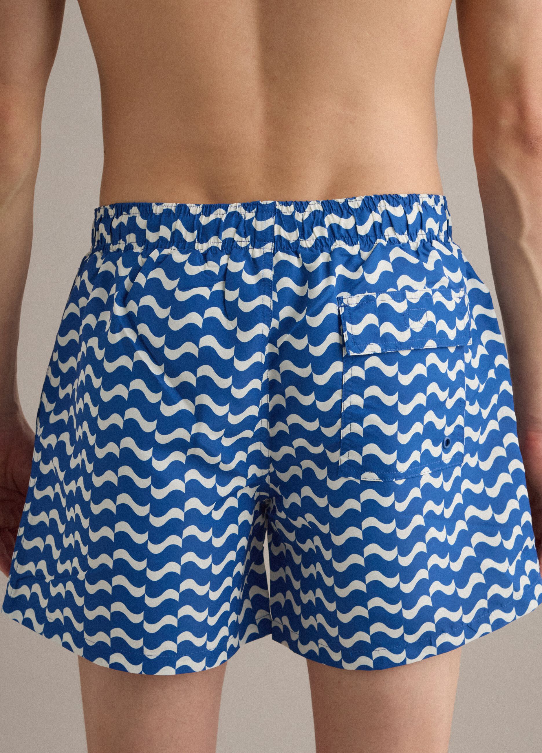 Blue swim shorts with wave pattern