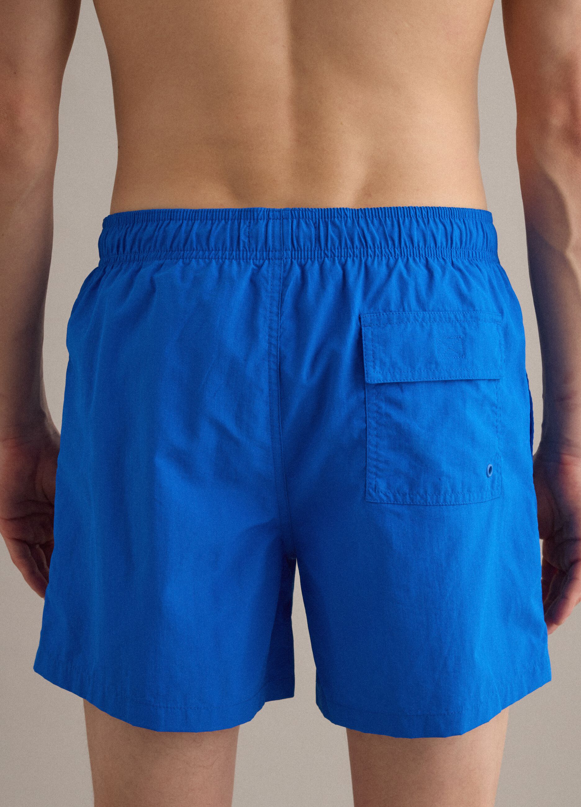 Blue swim shorts with elasticated waist and drawstring