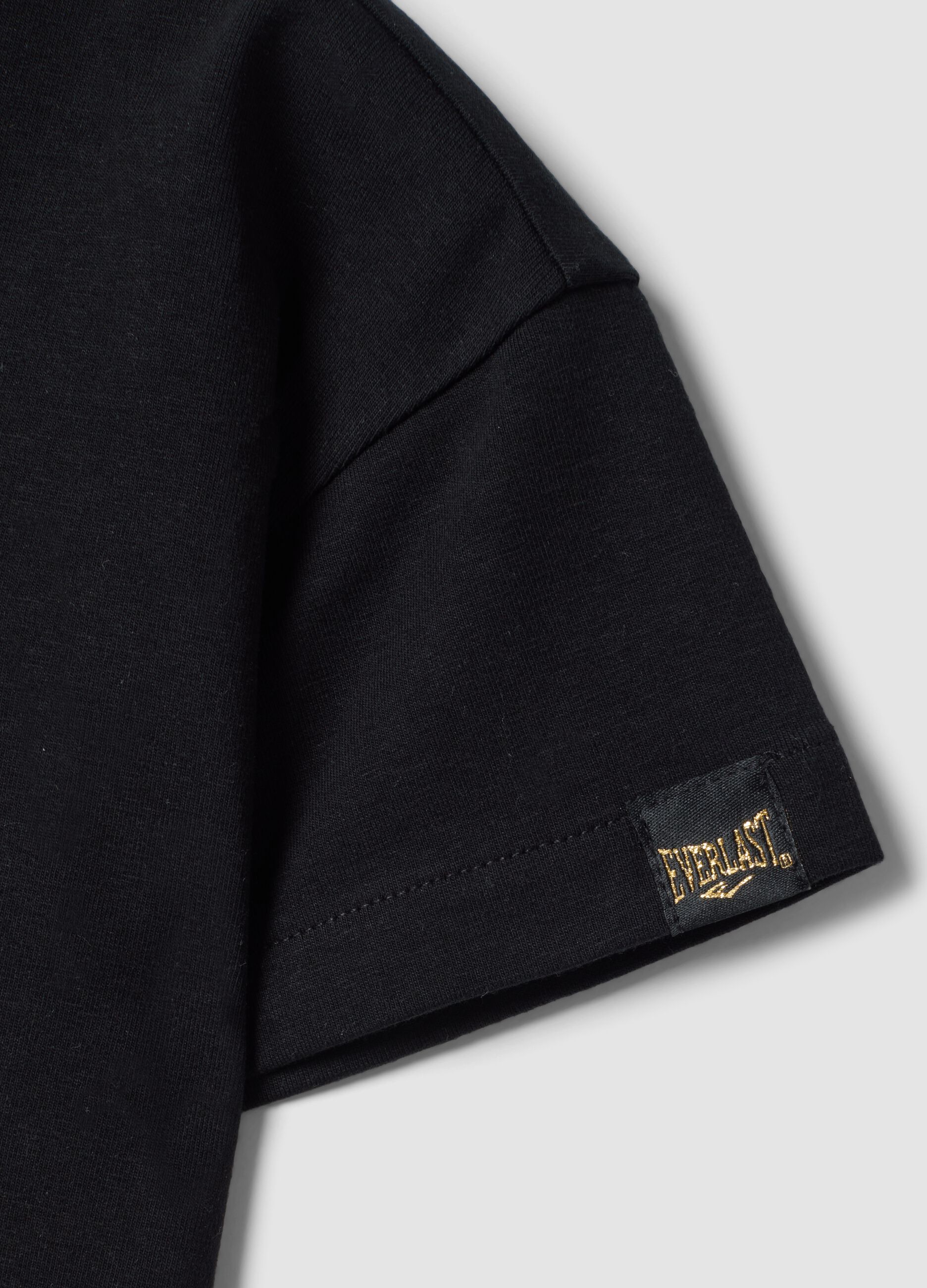 Camiseta cropped negra de algod&oacute;n el&aacute;stico con estampado para ni&ntilde;a