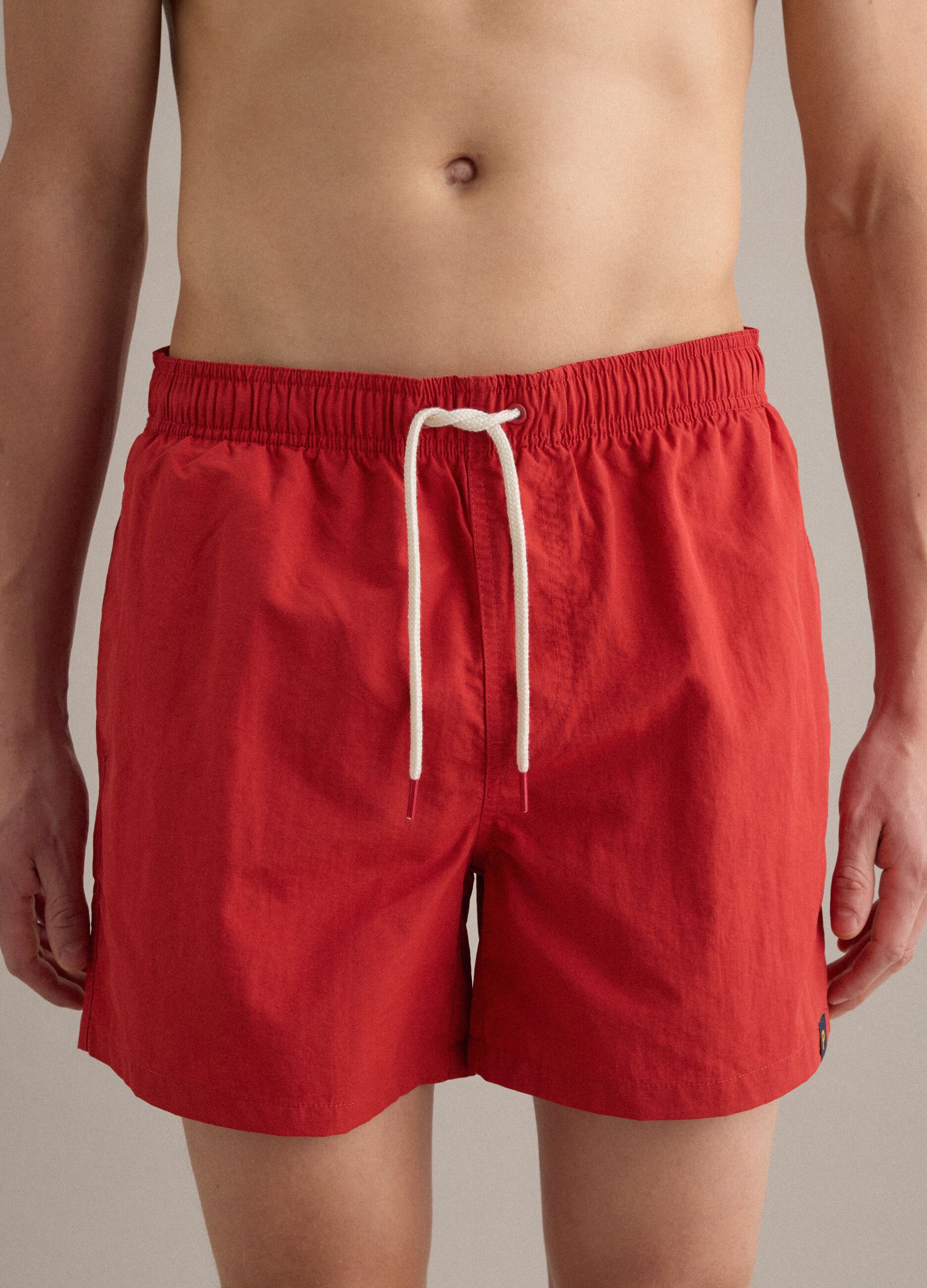 Red swim shorts with elasticated waistband and drawstring