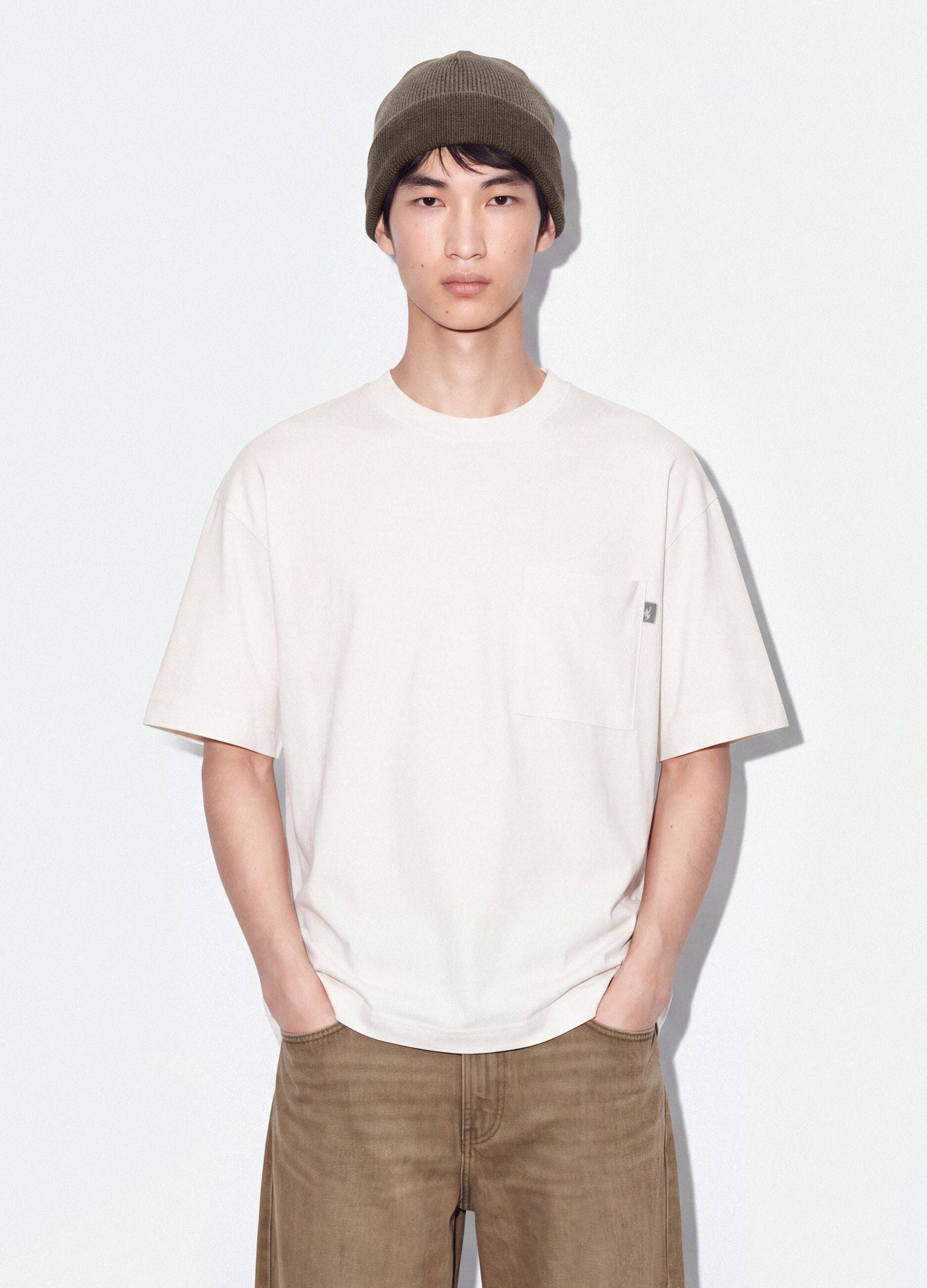 T-shirt branca em algod&atilde;o puro com gola redonda e bolso, corte boxy