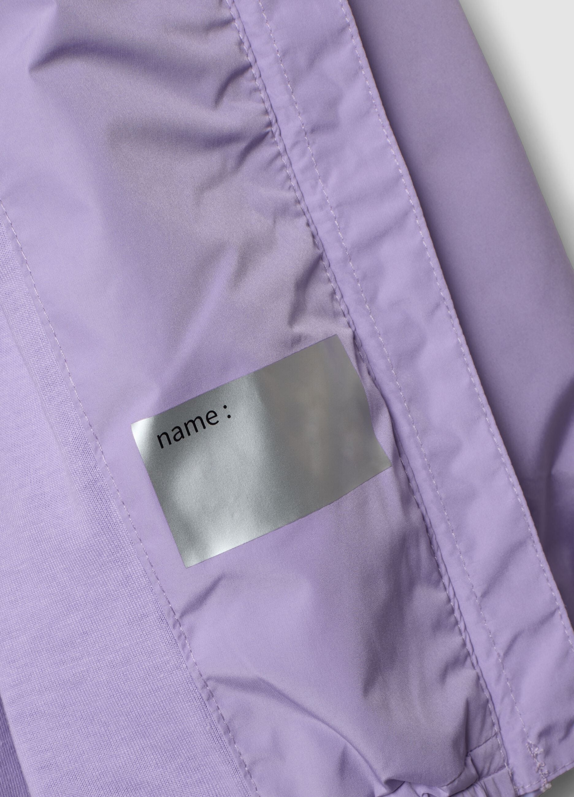 Casaco imperme&aacute;vel roxo com capuz e fecho de correr para menina, corte regular
