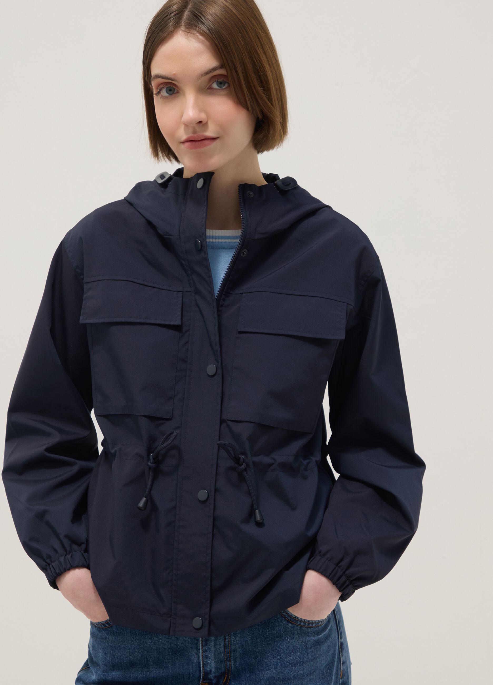 Casaco imperme&aacute;vel azul regular fit com bolsos e capuz