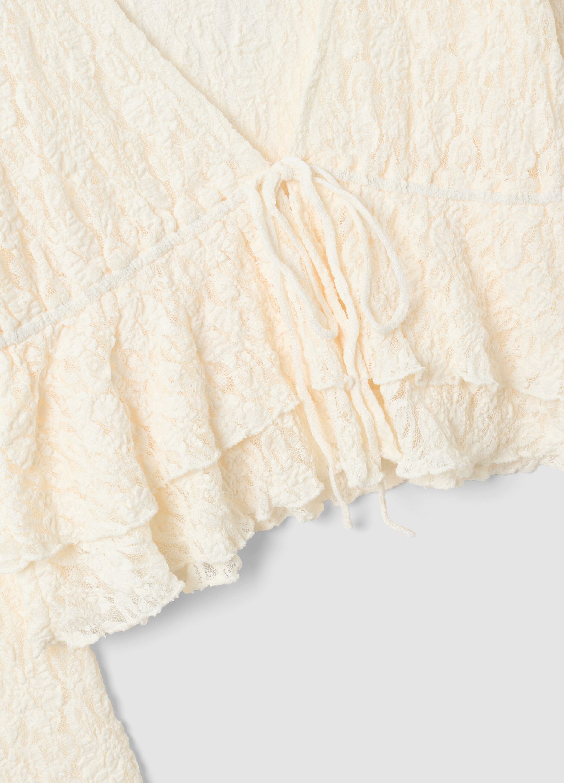 White stretch fabric top with deep V-neck and ruffle hem