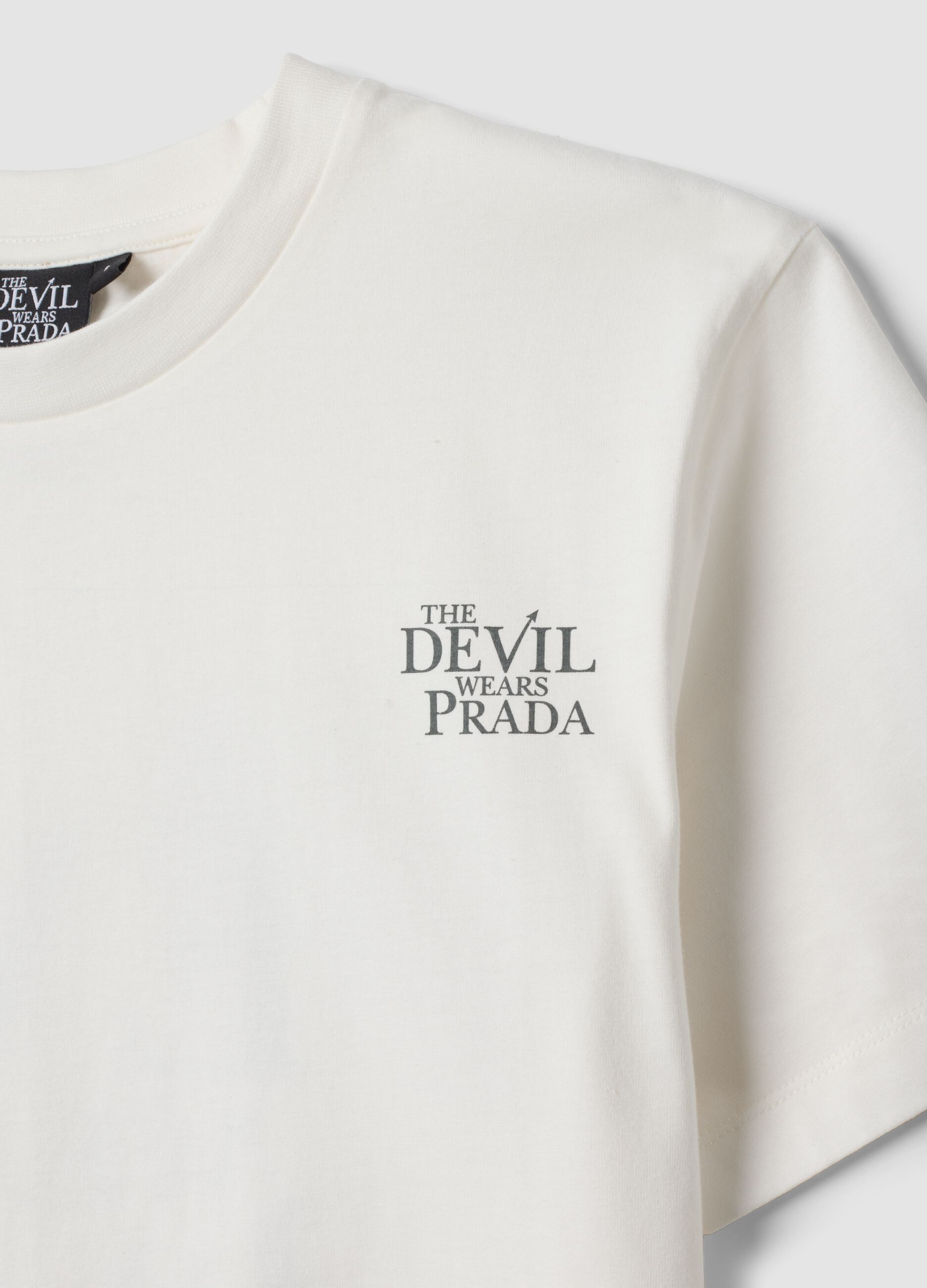 &Lambda;&epsilon;&upsilon;&kappa;ό T-shirt &alpha;&pi;ό 100% &beta;&alpha;&mu;&beta;ά&kappa;&iota; &mu;&epsilon; &sigma;&tau;ά&mu;&pi;&alpha; &laquo;&Omicron; &Delta;&iota;ά&beta;&omicron;&lambda;&omicron;&sigmaf; &Phi;&omicron;&rho;ά&epsilon;&iota; Prada&raquo;, oversized &gamma;&rho;&alpha;&mu;&mu;ή