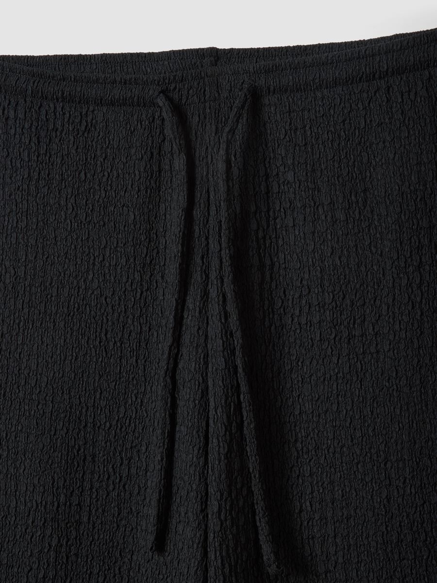 Schwarze Stretch-Hose mit weitem Bein und Crinkle-Optik_5