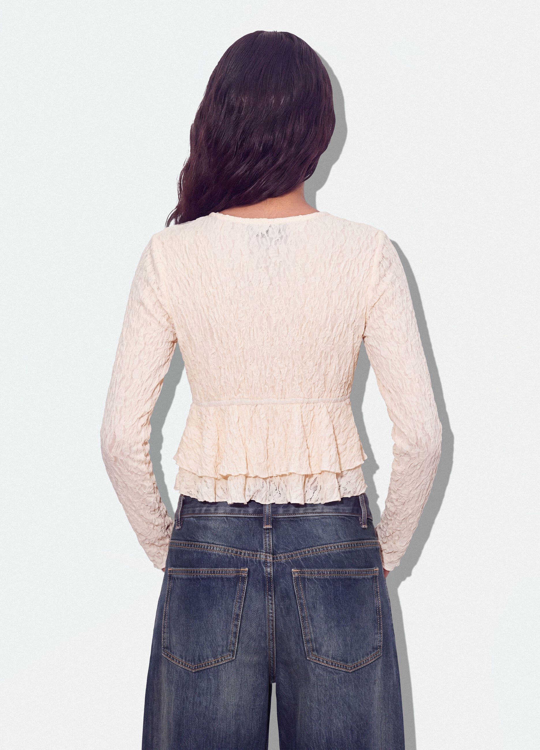 White stretch top with deep V-neck and ruffle trim