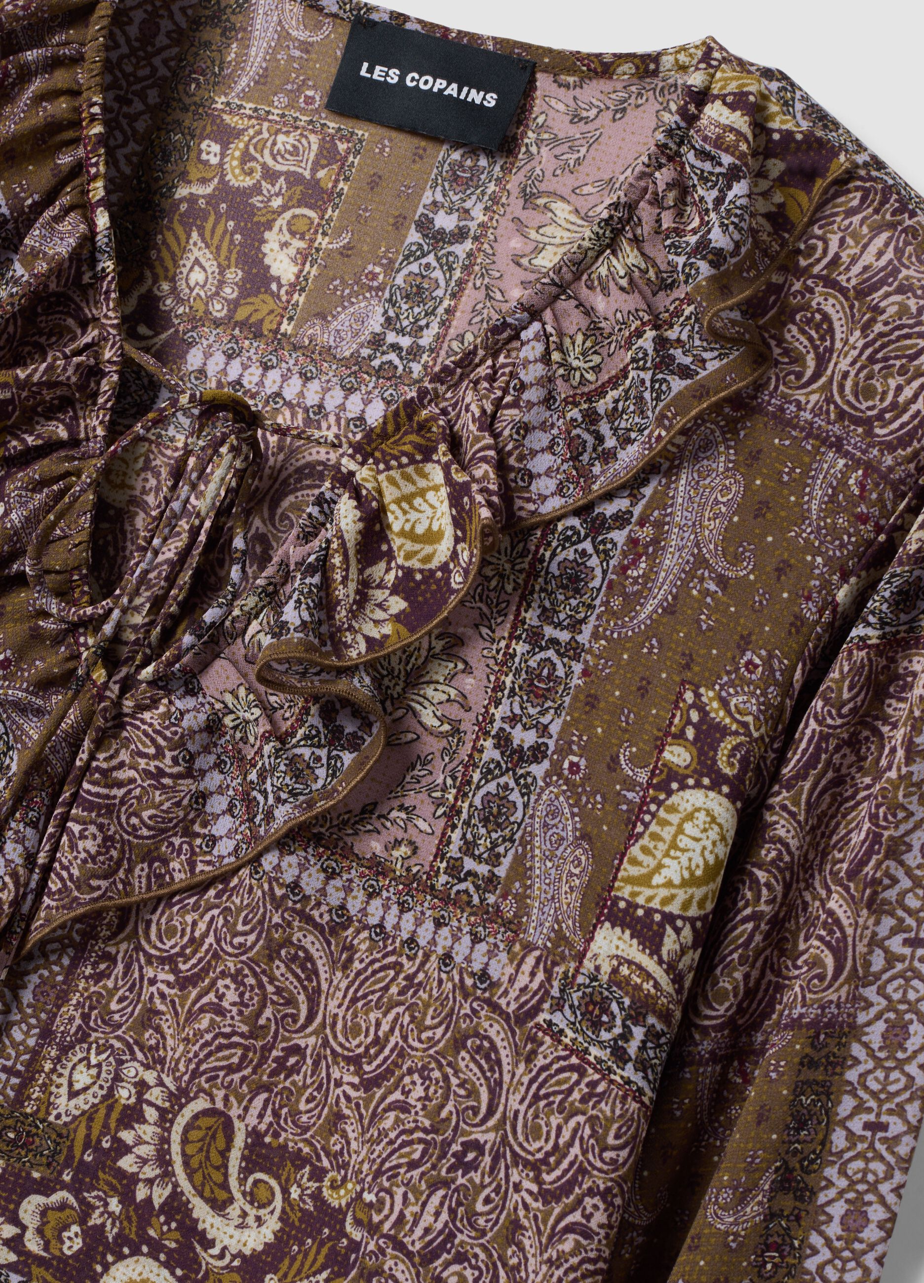 Violette Bluse mit Muster, Volants und Bindeschleife am Hals