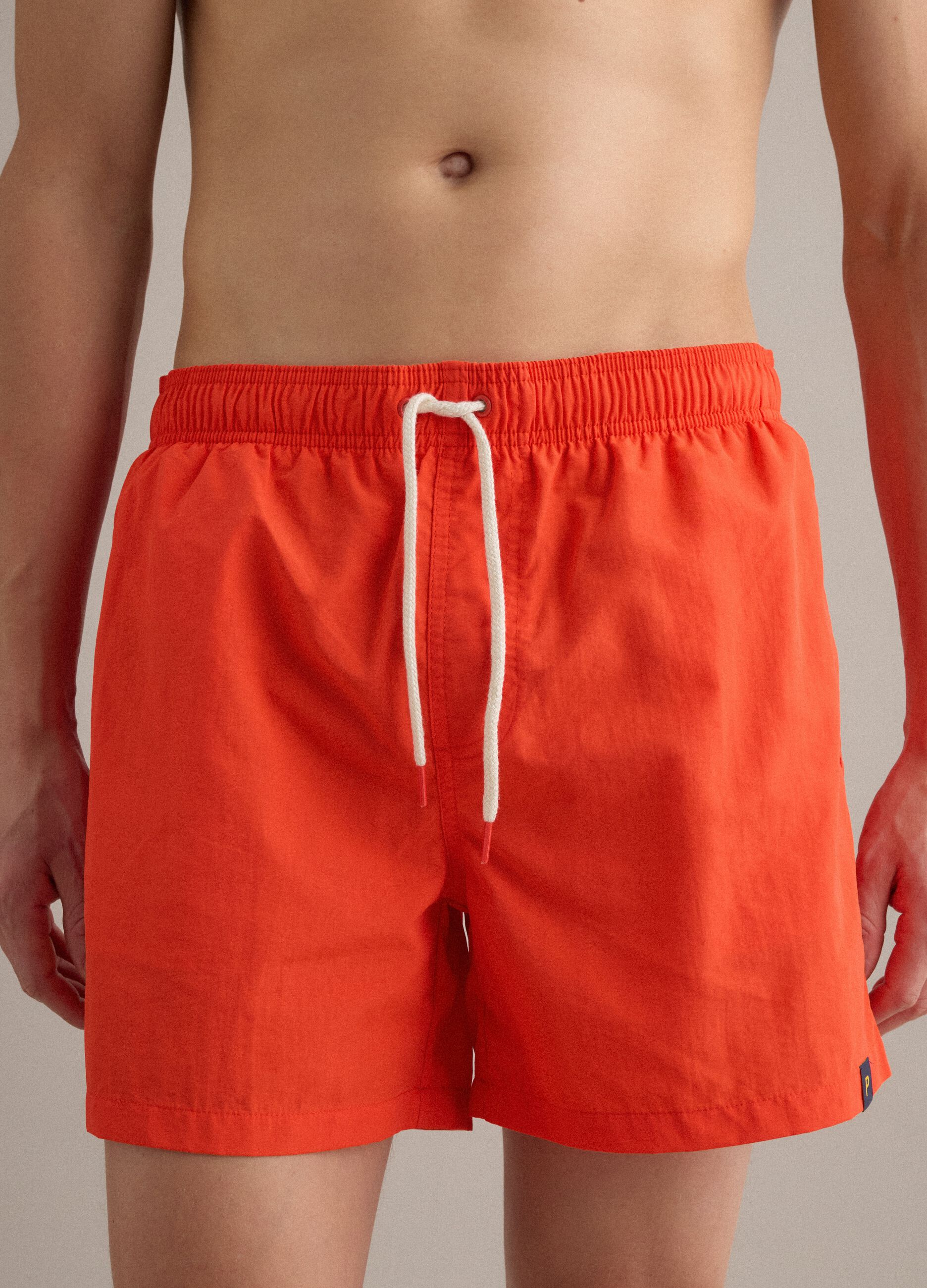 Orangefarbene Badeshorts mit elastischem Bund und Kordelzug
