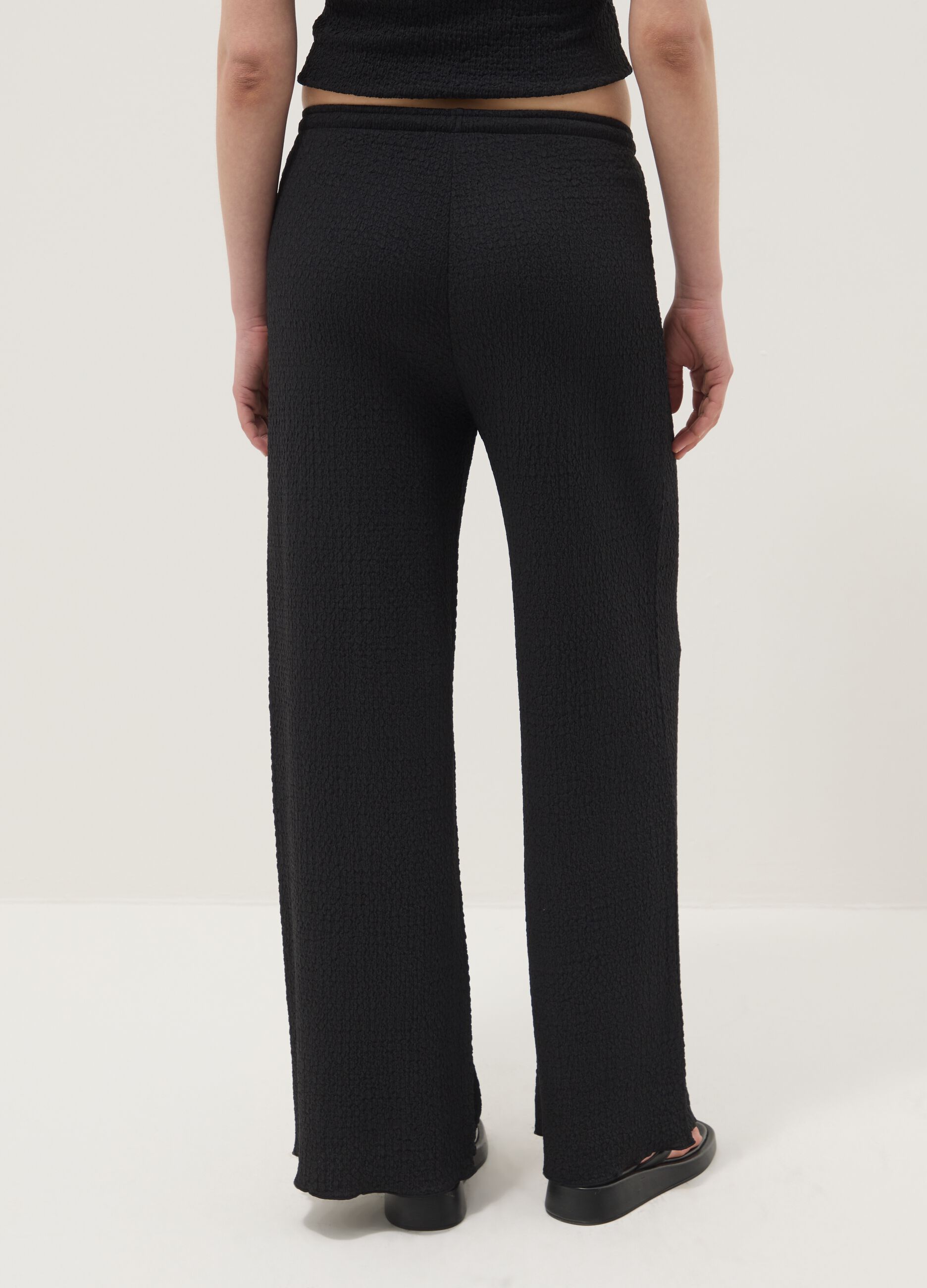Black stretchy wide-leg trousers with crinkled texture