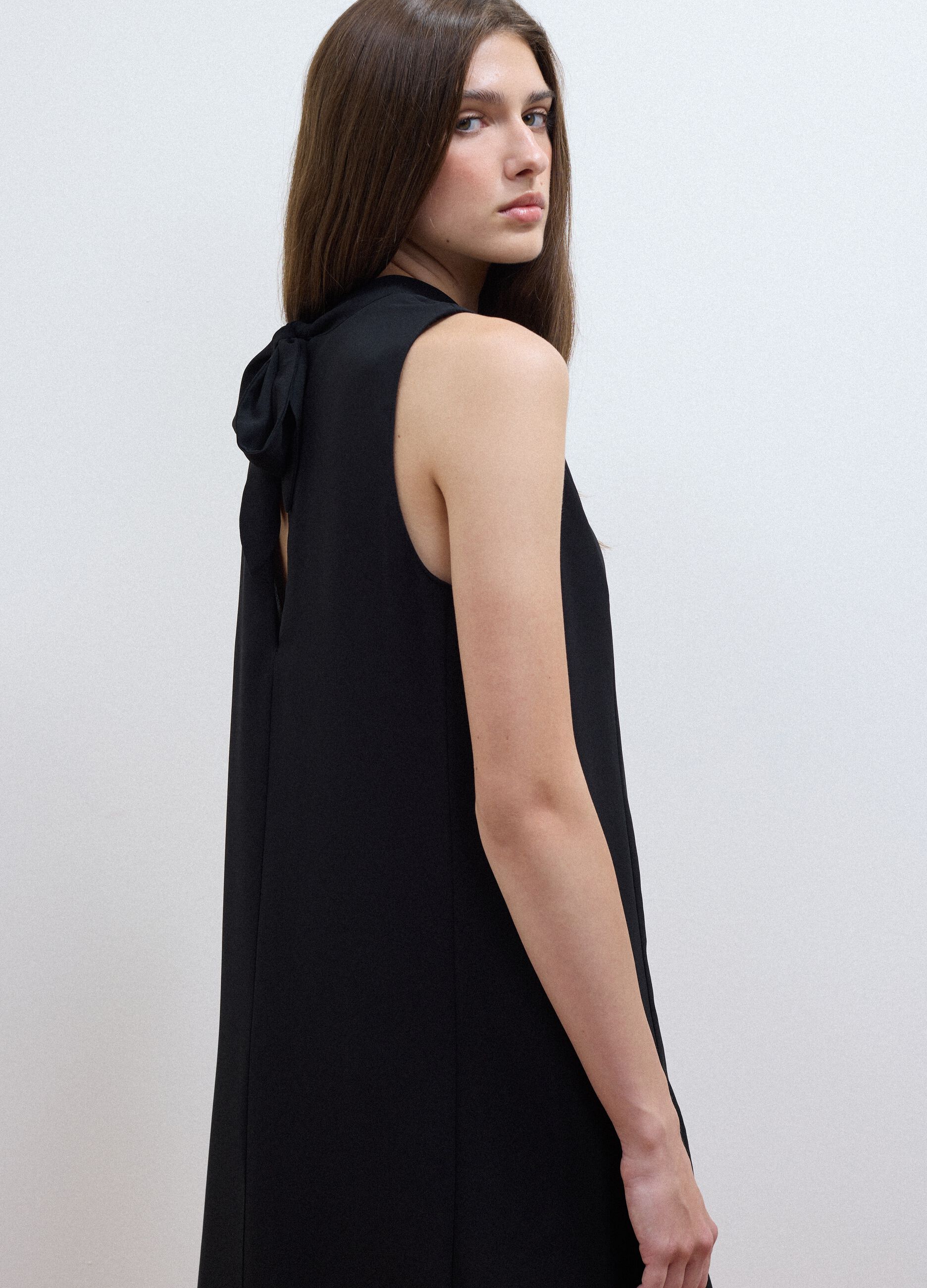 Black sleeveless high-neck slim-fit dress with bow
