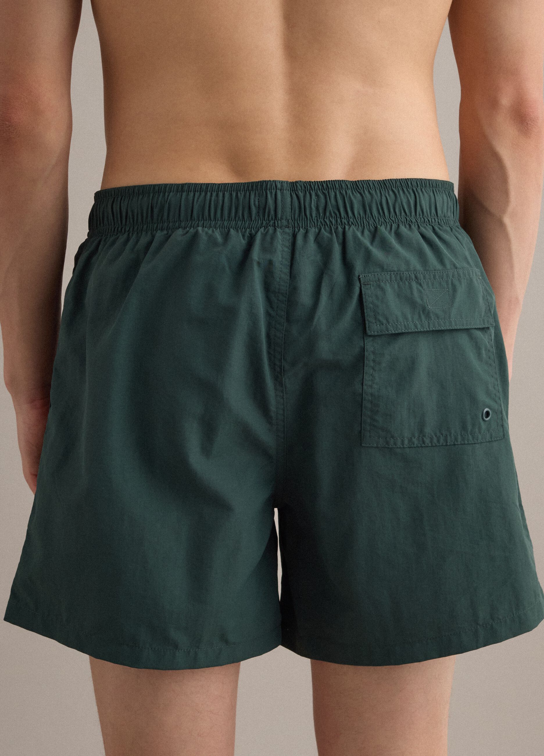 Green swim shorts with elasticated waistband and drawstring