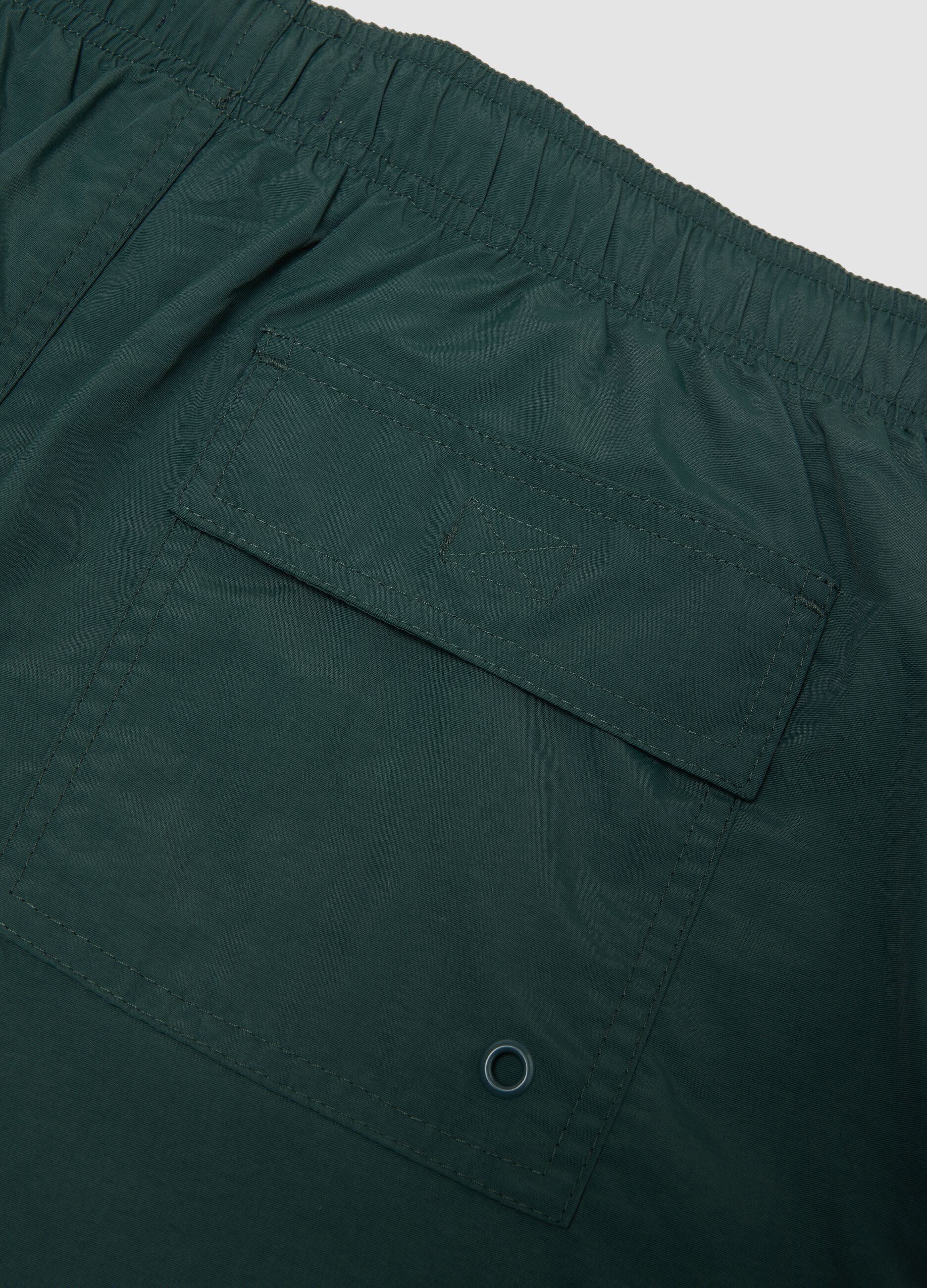 Green swim shorts with elasticated waistband and drawstring
