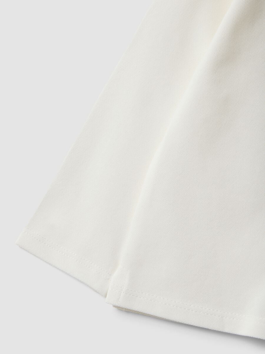 Polo bianca in cotone organico elasticizzato con dettagli volant per bimba_3