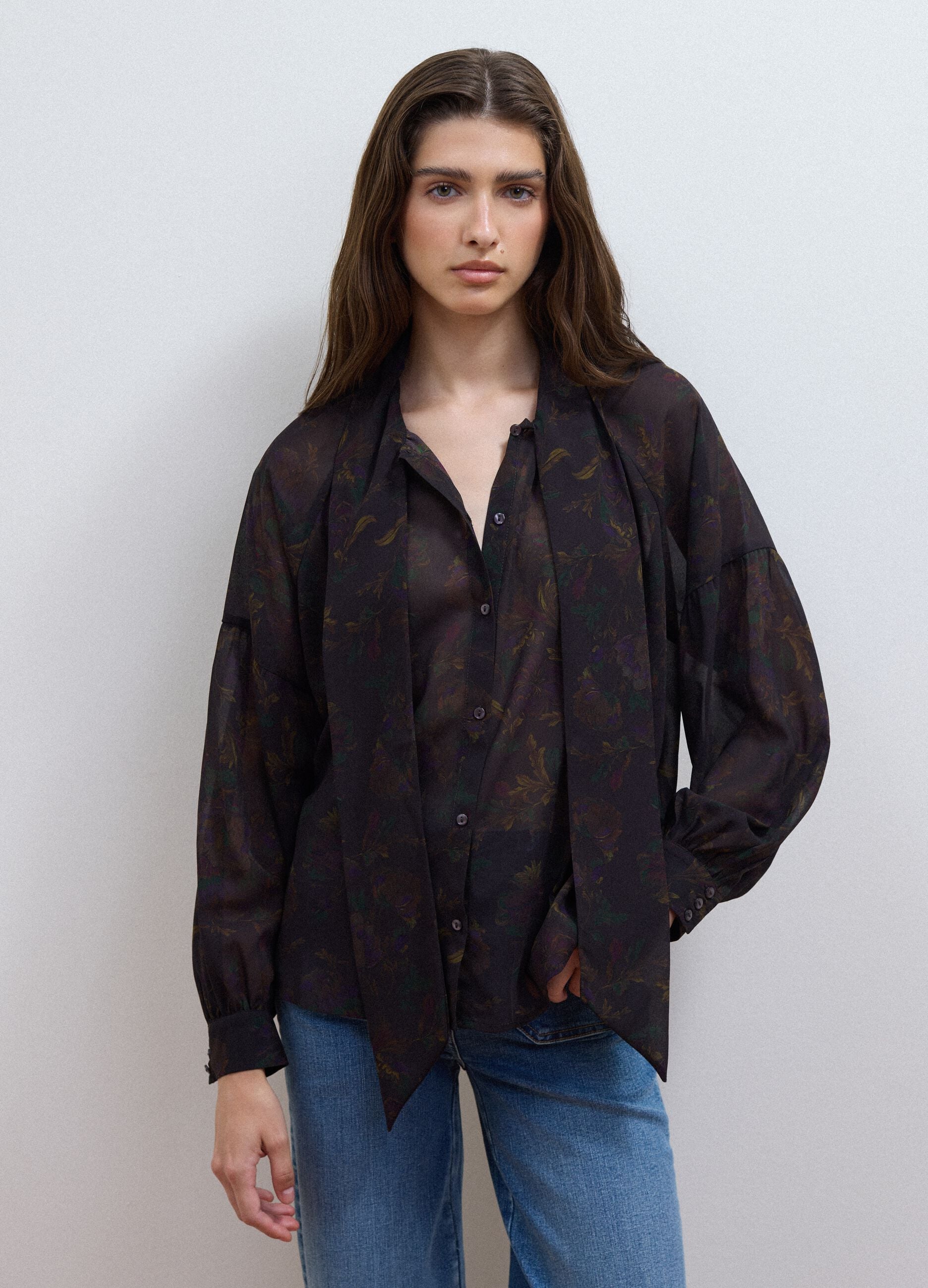 Camicia nera con fantasia floreale e fiocco al collo