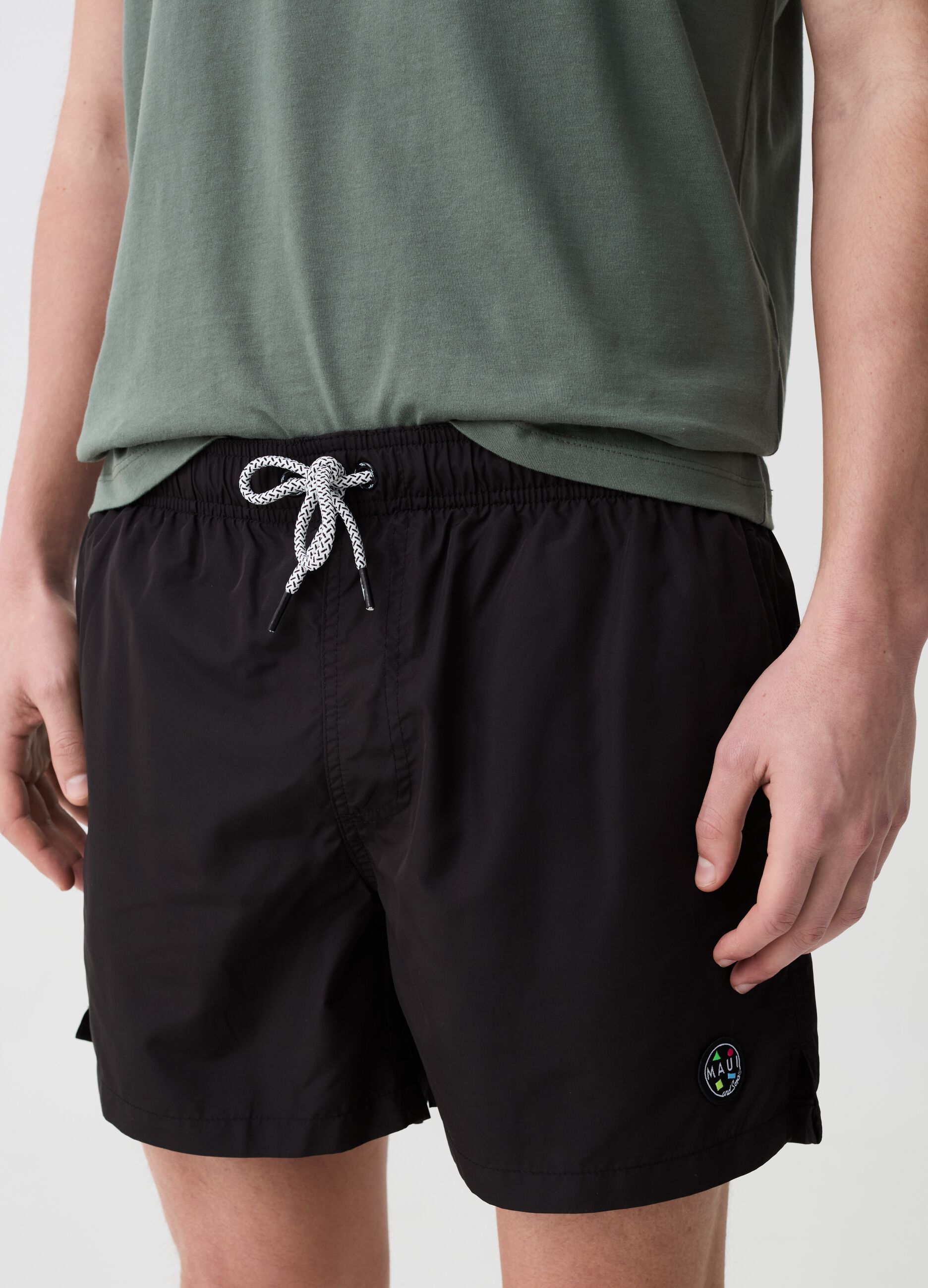 Swimming trunks with logo patch