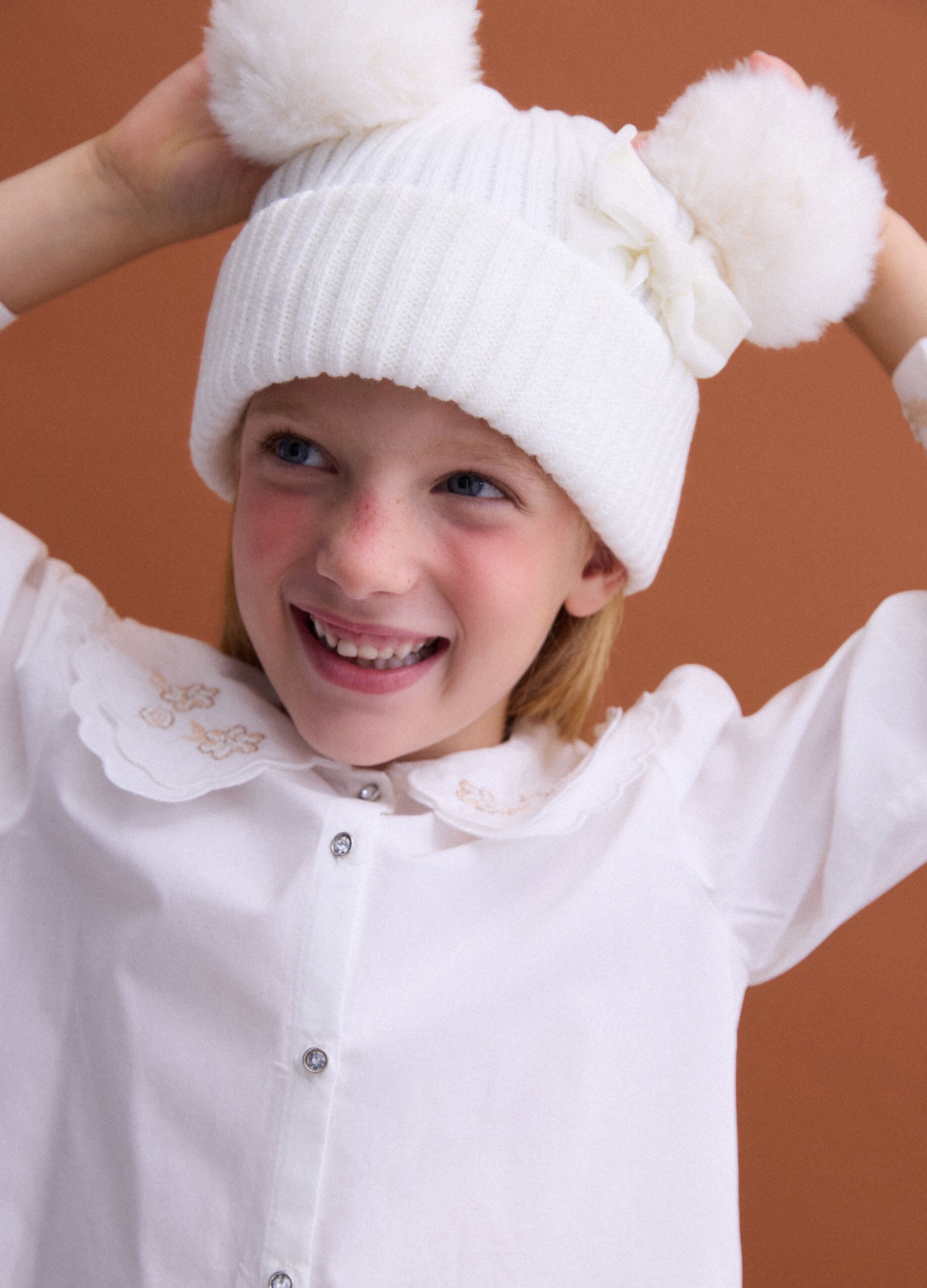 Gorro branco em malha canelada com la&ccedil;o e pompons