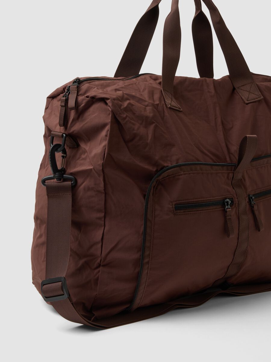 Brown foldable travel bag with shoulder strap and zip pockets_1