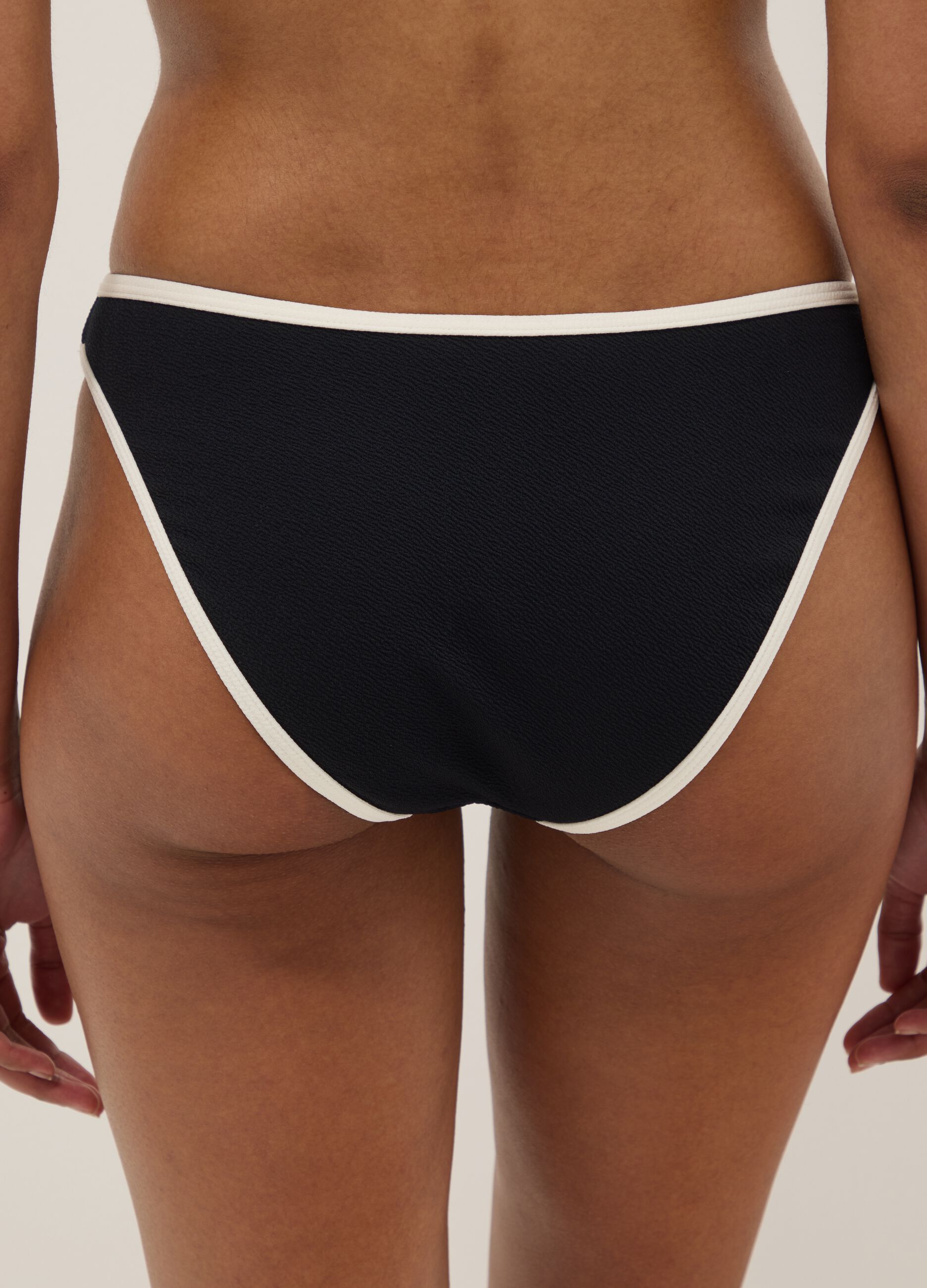 Slip de banho preto em tecido el&aacute;stico com debrum branco