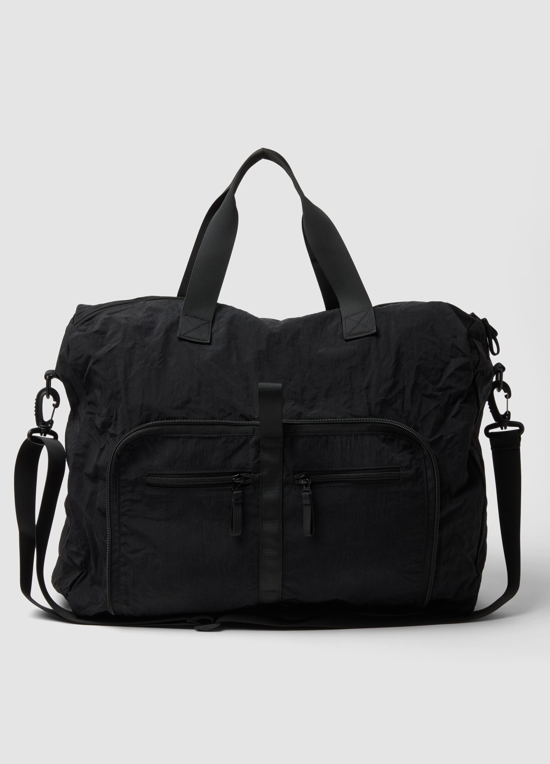 Black foldable travel bag with shoulder strap and zipped pockets