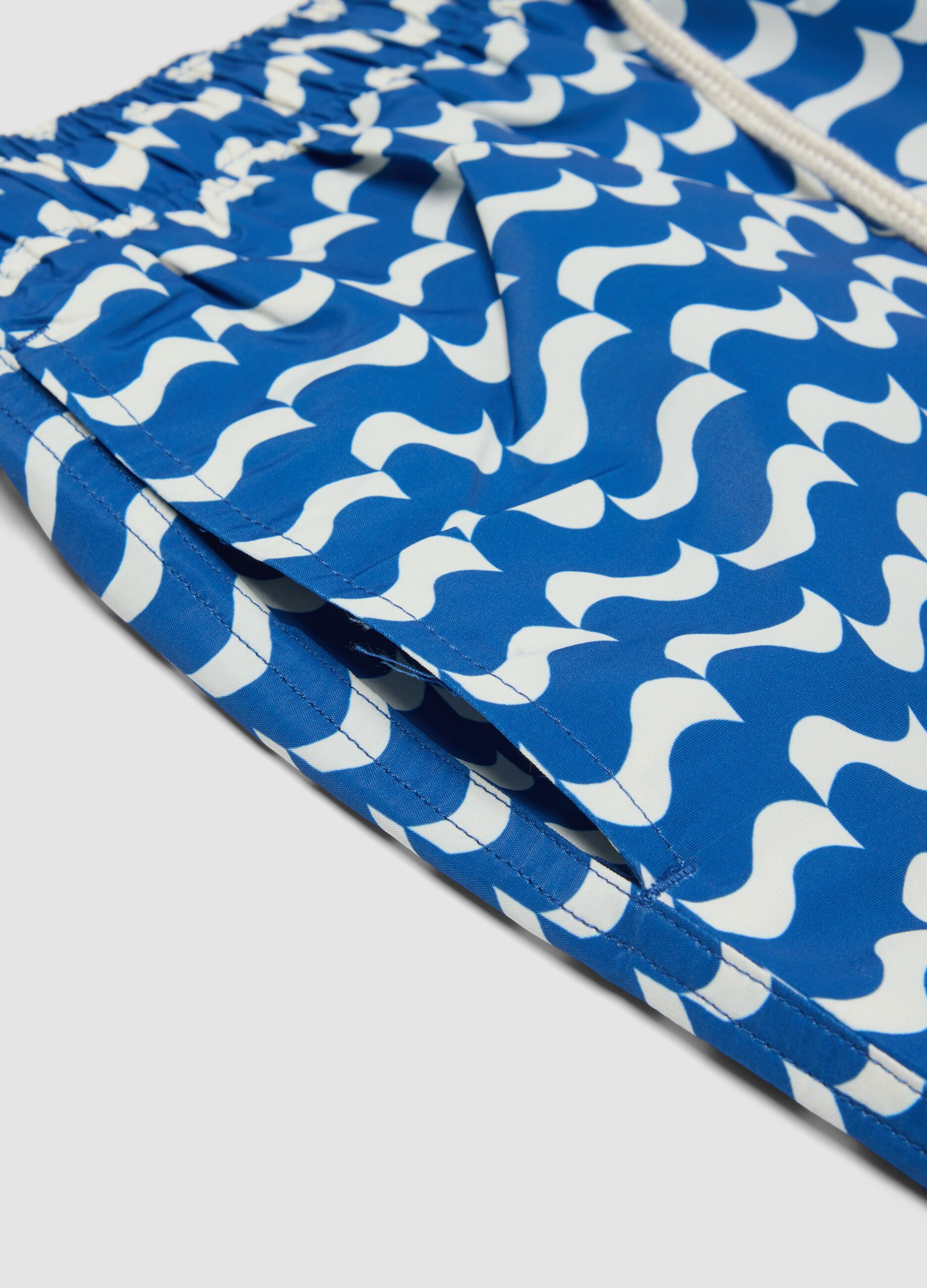 Blue swim shorts with wave pattern
