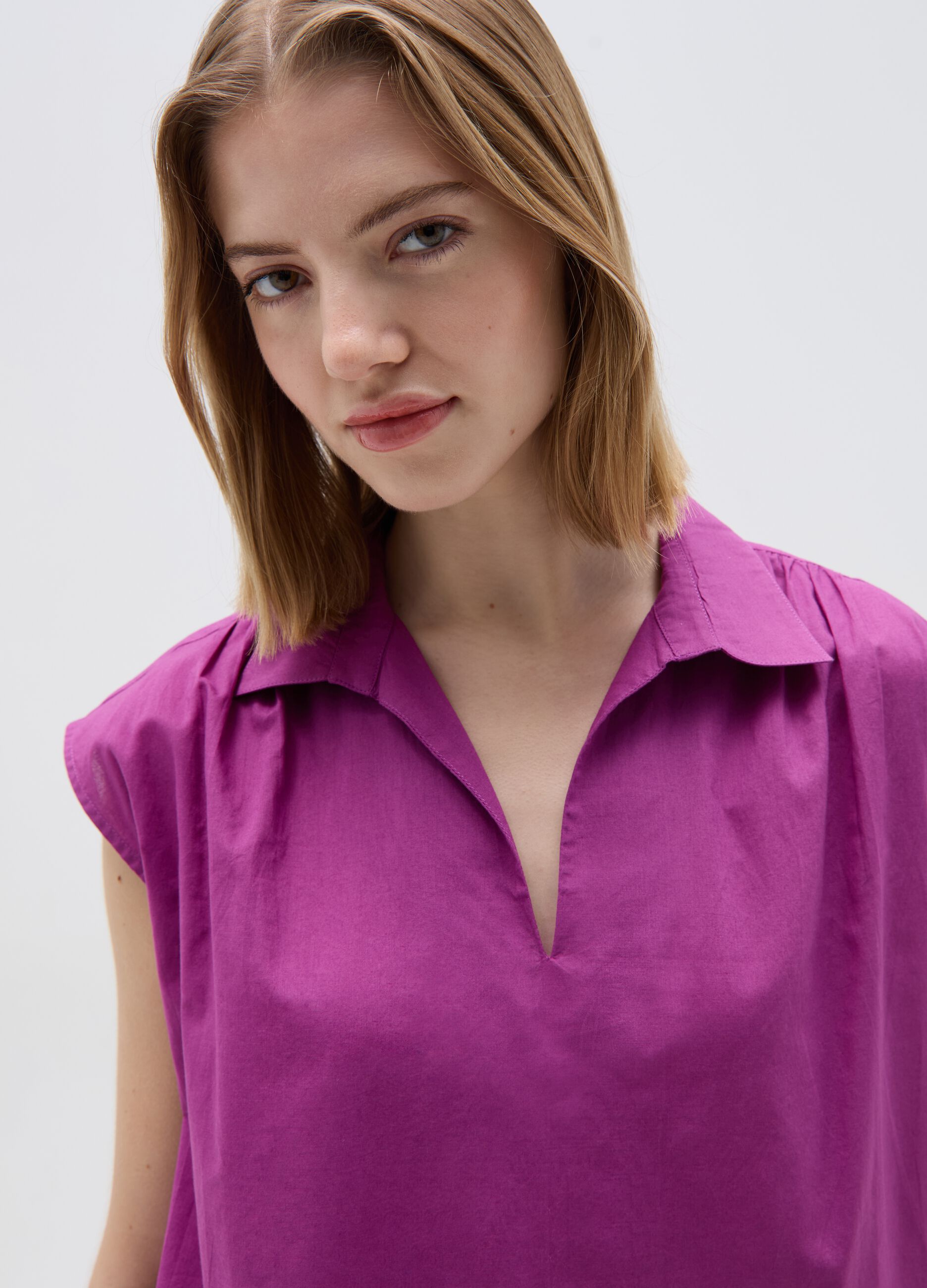 Sleeveless blouse with polo neck
