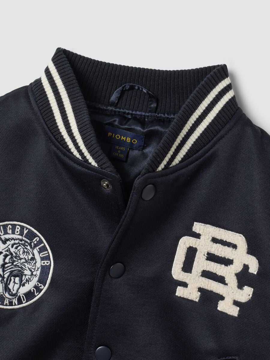 Blue varsity jacket with beige sleeves and print for boys_1