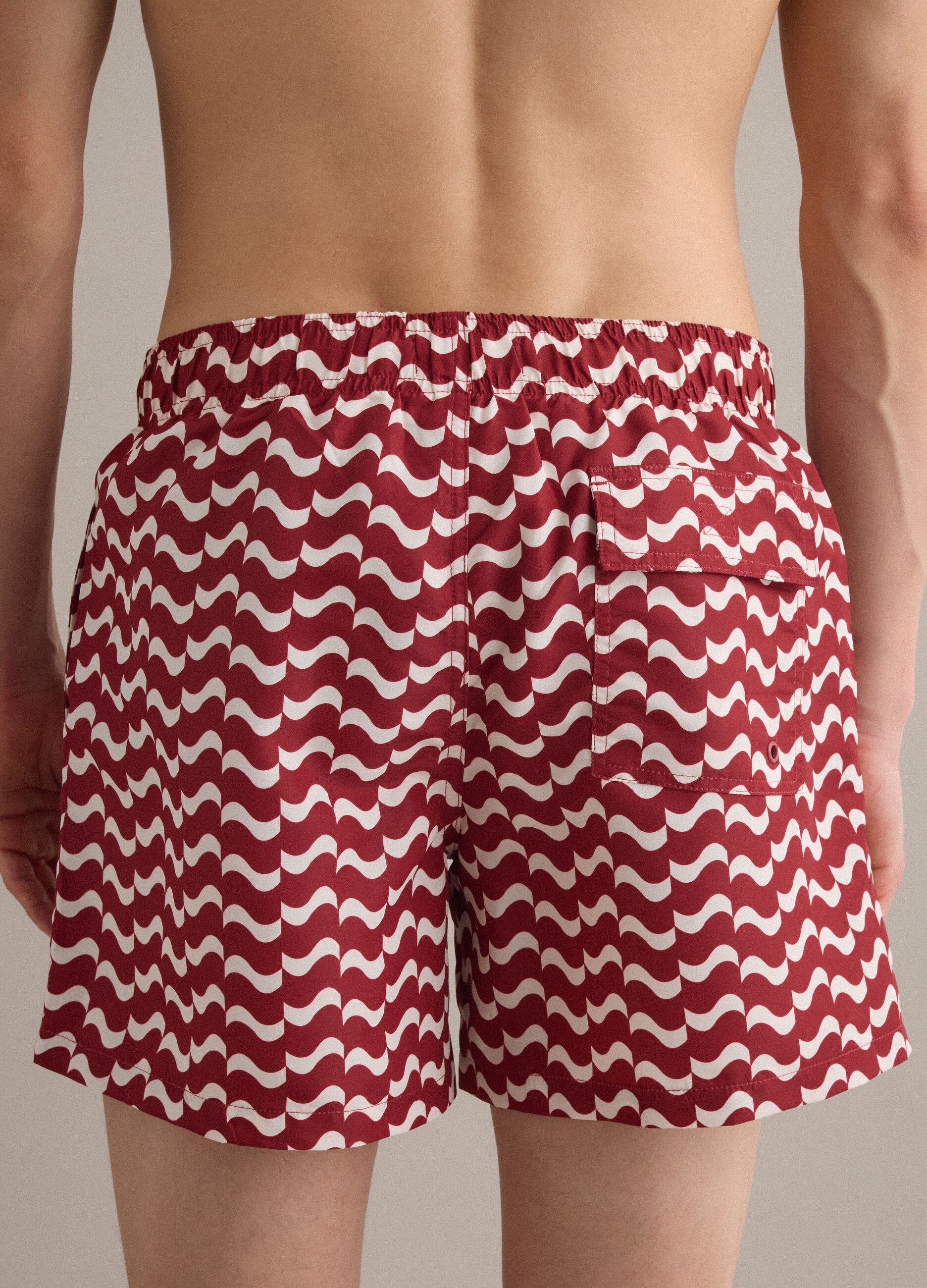 Red men&rsquo;s swim shorts with all-over print